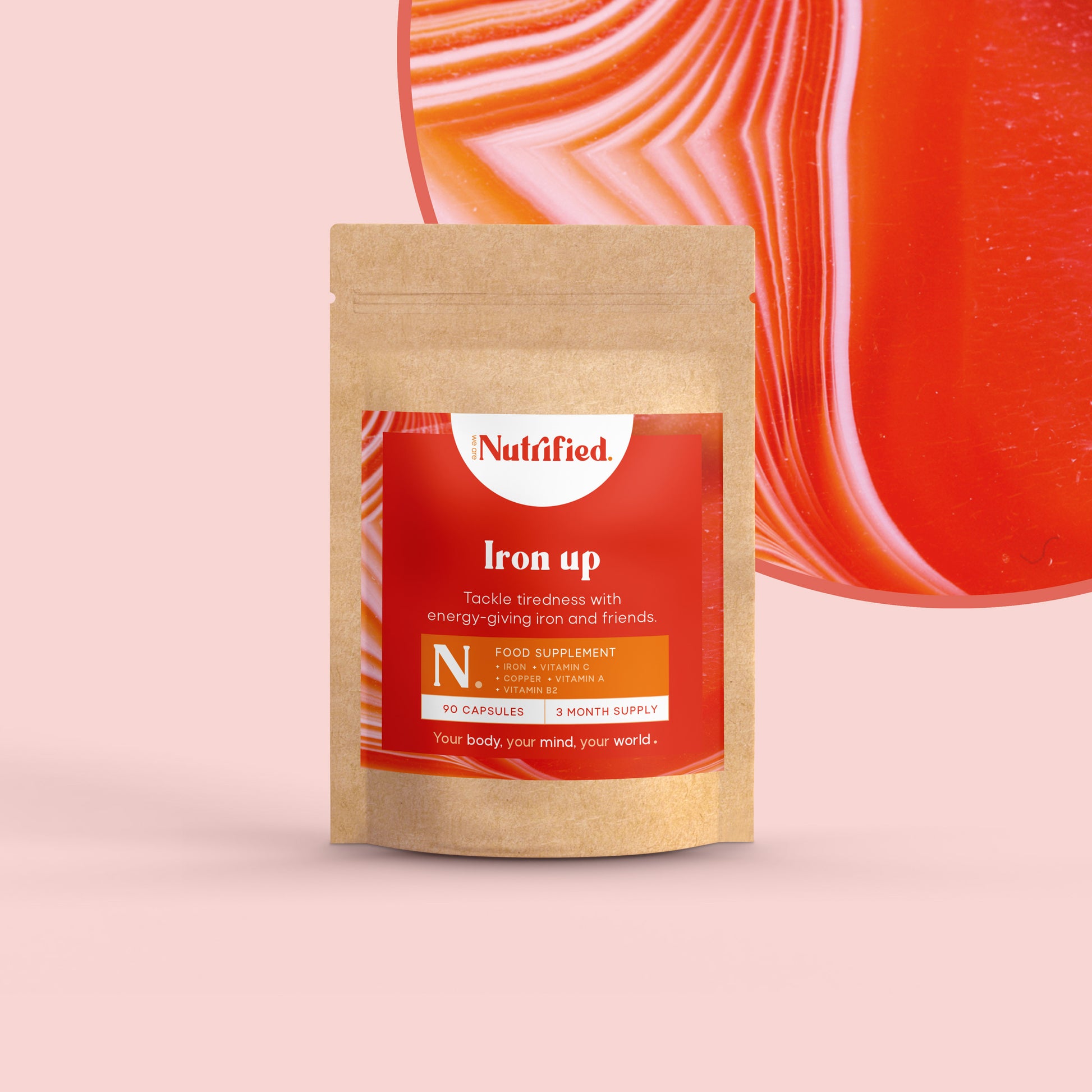 A pouch of Iron Up 90 capsules with a red label, placed against an abstract red background.